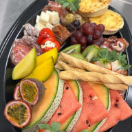 Medelhavsbricka med gran serrano, prosciutto crudo, salame toscano, tryffelsalami, chorizo, mini saucisse, paj med Västerbottenost, tomme le Chisteria (ost), magnumoliver, fetaostfyllda gemis, soltorkad tomat-tapenad, smördegsstänger, mango, melon, pasionsfrukt, vindruvor, kiwi och jordgubbar.
