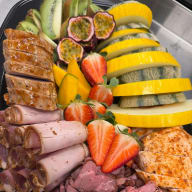 Exotisk lyxplanka med passionsfrukt, jordgubbar, kiwi, mango, melon, vindruvor, olika sorters ost, rostbiff, pastrami, fläskfilé och kycklingfilé.