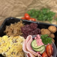 Matlåda med skivad skinka, potatisgratäng, köttbullar och sallad.
