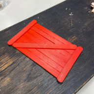Glasspinnar formade som en liten dörr målad i röd färg.
