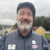 Person i ICA-uniform med namnbricka "Pelle" och ICA-märken.