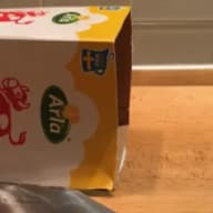 En kartong med logotyper står på en träyta.