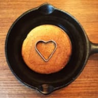 En pannkaka i en stekpanna med ett hjärtformat mönster på ovansidan.