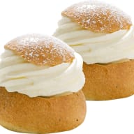 två semlor med vispad grädde i delad vetebulle.