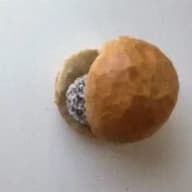 En hamburgerbröd med en rund fyllning inuti.