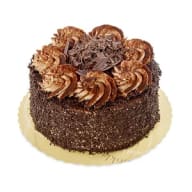 Chokladtårta med chokladgrädde, riven choklad och dekorativa chokladspån på toppen.