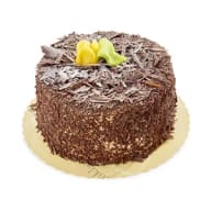 Chokladtårta täckt med riven choklad och dekorerad med gul marsipanros på toppen.