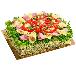 Smörgåstårta dekorerad med skinka, ost, sallad och paprikaringar.