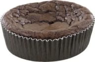 Bakad rund kladdkaka av choklad i veckad pappersform med sprucken topp.