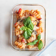 Ratatouille med pasta i en matlåda på ljus bakgrund