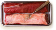 En tallrik med två stora köttbitar och en gaffel.