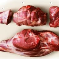 Fyra olika köttbitar ligger på en vit yta, varav en är större och har ben.