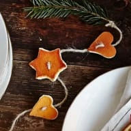 Bitar av apelsinskal formade som stjärnor och hjärtan på ett jutesnöre.