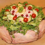 En sallad med grönsaker, bönor och skinka serveras på en tallrik.