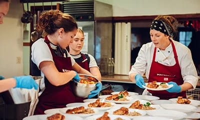 Personer som lagar mat i storkök.