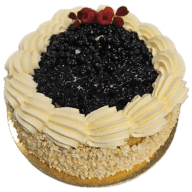Maxitårta. Rund tårta med bärfyllning i mitten och spritsad kräm runt kanten.