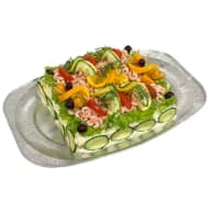 Smörgåstårta toppad med räkor, skivade grönsaker, citronklyftor och dill på ett serveringsfat.