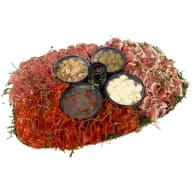 Stort upplagt fat med charkuterier och små skålar fyllda med tillbehör.