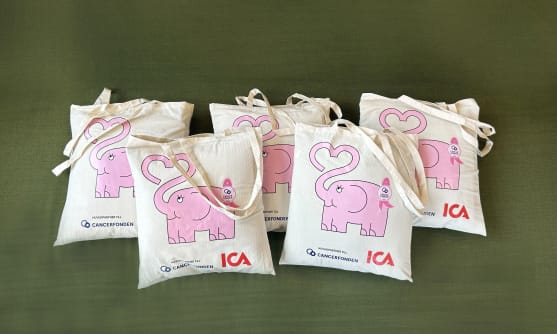 Fem tygkassar med rosa elefant-tryck på ligger på ett bord.