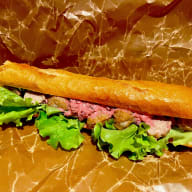 Baguettesmörgås med köttbullar, rödbetssallad och krämig dressing mot en pappersbakgrund