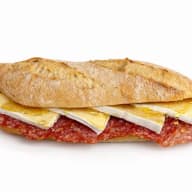 Baguettesmörgås fylld med salami, skivor brie och honung.