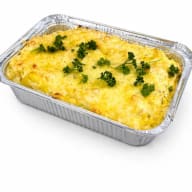 En gratäng med persilja serveras i en aluminiumform på ett bord.