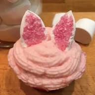 En cupcake med frosting formad som kaninöron och dekorerad med glittrande kristaller.