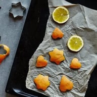 Apelsinskal och skivade apelsiner på en plåt med bakplåtspapper