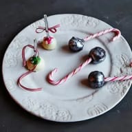 En tallrik med godis och frukt, inklusive polkagrisar, klubbor och bär.