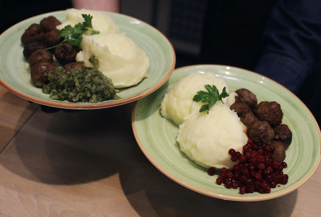 Två tallrikar med potatismos, kött och grönsaker står på ett bord.