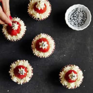 Cupcakes med vit glasyr, jordgubbar och strössel