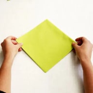 Två händer som håller i en grön servett