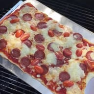 En nygräddad pizza som bakats på en grill.