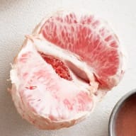 skalad grapefrukt mot vit bakgrund
