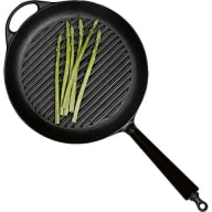 En stekpanna med grillmönster innehåller några långa grönsaker.