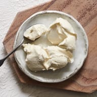 En tallrik med klumpar av glass står på en träskärbräda.