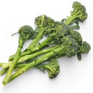 Broccoli med stjälkar och buketter ligger på en vit yta.