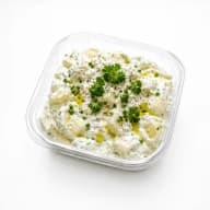 En skål med yoghurtsås garnerad med persilja och kryddor.
