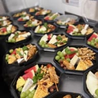 Flera plockbrickor med ost, frukt och tillbehör uppradade för servering.