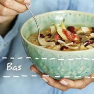 En person håller en skål med frukost innehållande fikon och andra ingredienser.