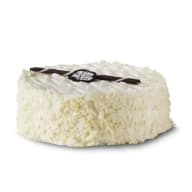 Vit tårta med ett choklademblem på toppen.