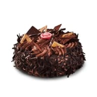 Elegant chokladtårta dekorerad med hyvlad choklad, chokladbitar och en rosa marsipanros.