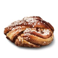 Kanelbulle i knutform toppad med pärlsocker.
