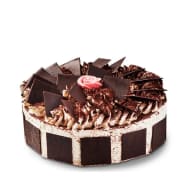Klassisk Schwarzwaldtårta med grädde, chokladdekorationer och en rosa ros på toppen.
