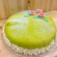 En tårta med rosor på toppen står på ett bord.