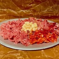 Fat med skivade charkuterier och tärnade ostbitar.