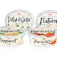 Fyra runda plastförpackningar med olika pålägg från ICA visas, inklusive vitlök och örter, naturell, pepparrot samt paprika och chili.