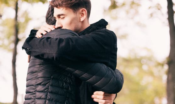 Två personer som kramas.