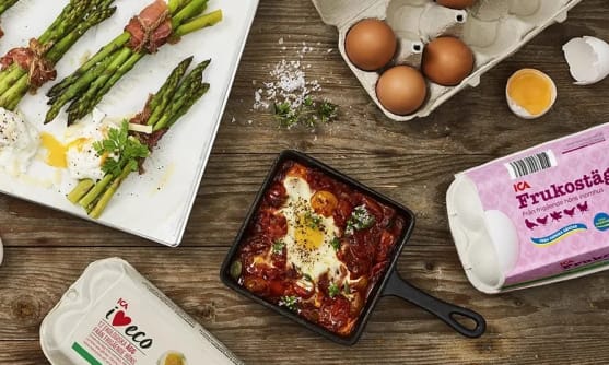 Äggkartonger med ägg av olika slag - ICA I love eco och ICA frukostägg. Sparrisknippen och en liten stekpanna med shakshuka med ägg. Ägghalvor av kokta ägg.