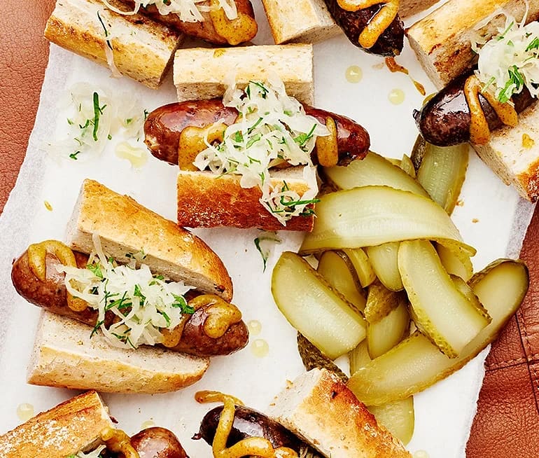 Kryddkorvar och surkål i baguette med saltgurka och senap